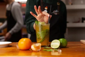 Bartender preparing craft cocktails in KL with fresh citrus, mint and ice, showing why the drink experience feels more refined.